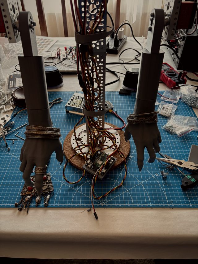 Lupa's forearms and bangled hands mounted on the aluminum frame before dressing, servo wiring running up the spine