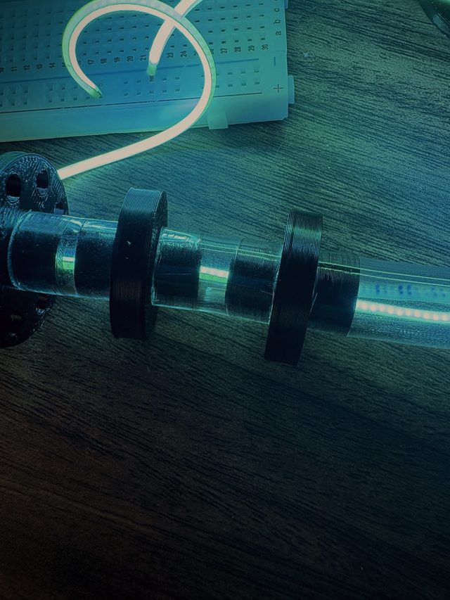 Close-up of the lit tube passing through black servo discs