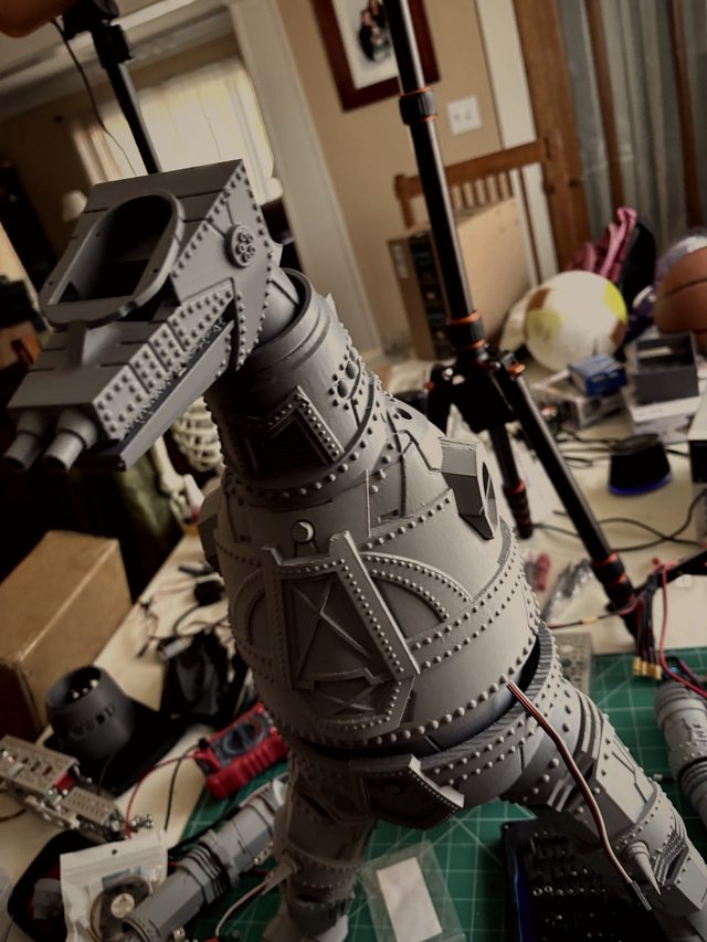 Low-angle view of MechaGodzilla's head and armored torso on the workbench