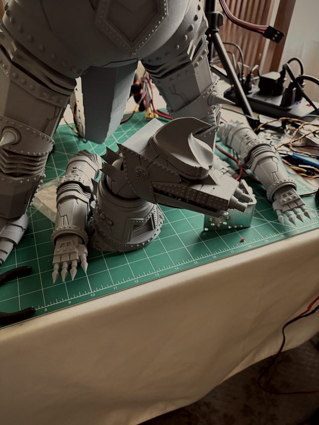 MechaGodzilla legs from behind with the detached head assembly and clawed forearms on a cutting mat