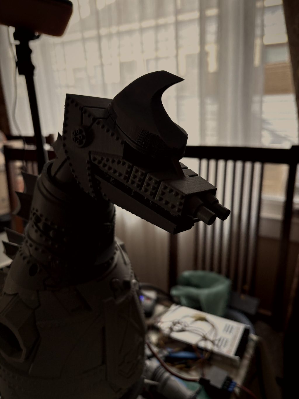 Close-up profile of MechaGodzilla's head with crest horn and twin snout cannons, backlit by a window