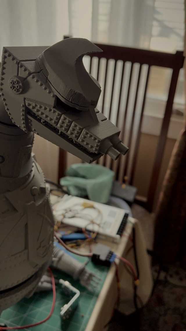 Tall close-up of MechaGodzilla's head in profile showing the toothed jaw and twin snout cannons