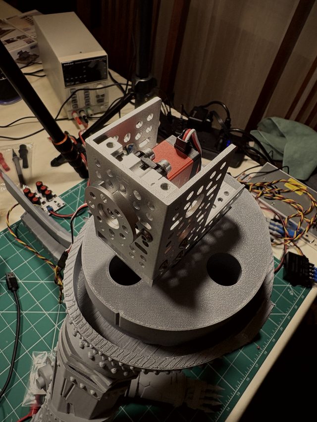 Close-up of the waist servo mounted in its aluminum bracket, bench power supply behind