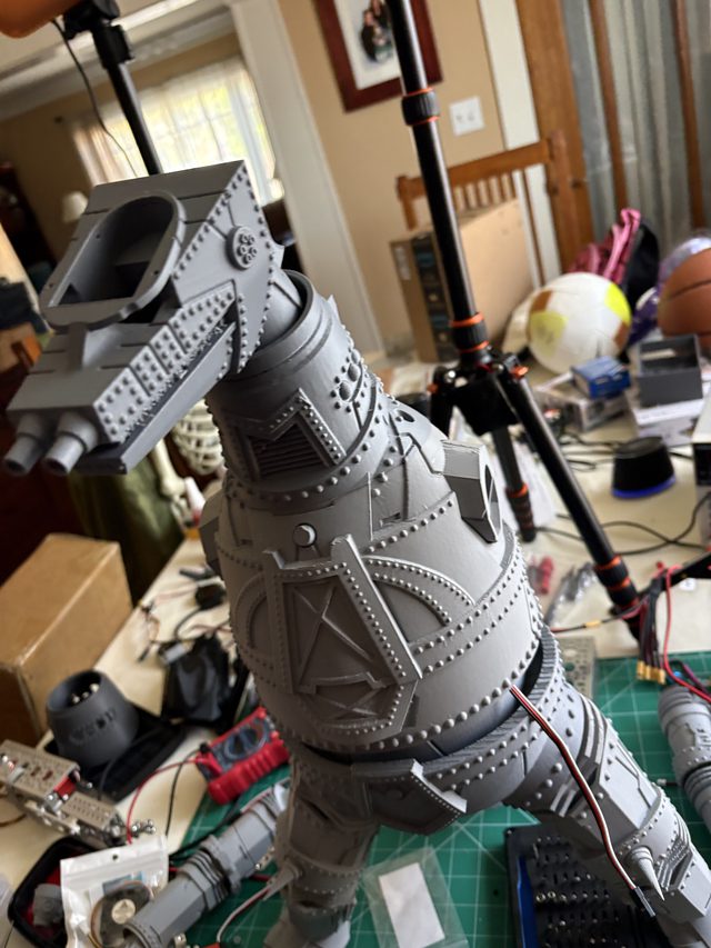 Low-angle view of MechaGodzilla's head and armored torso on the workbench