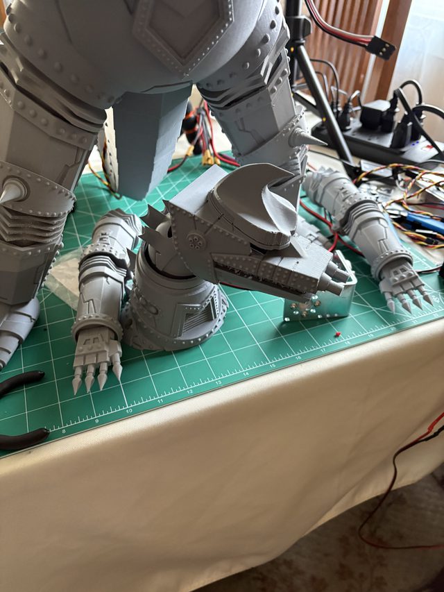 MechaGodzilla legs from behind with the detached head assembly and clawed forearms on a cutting mat