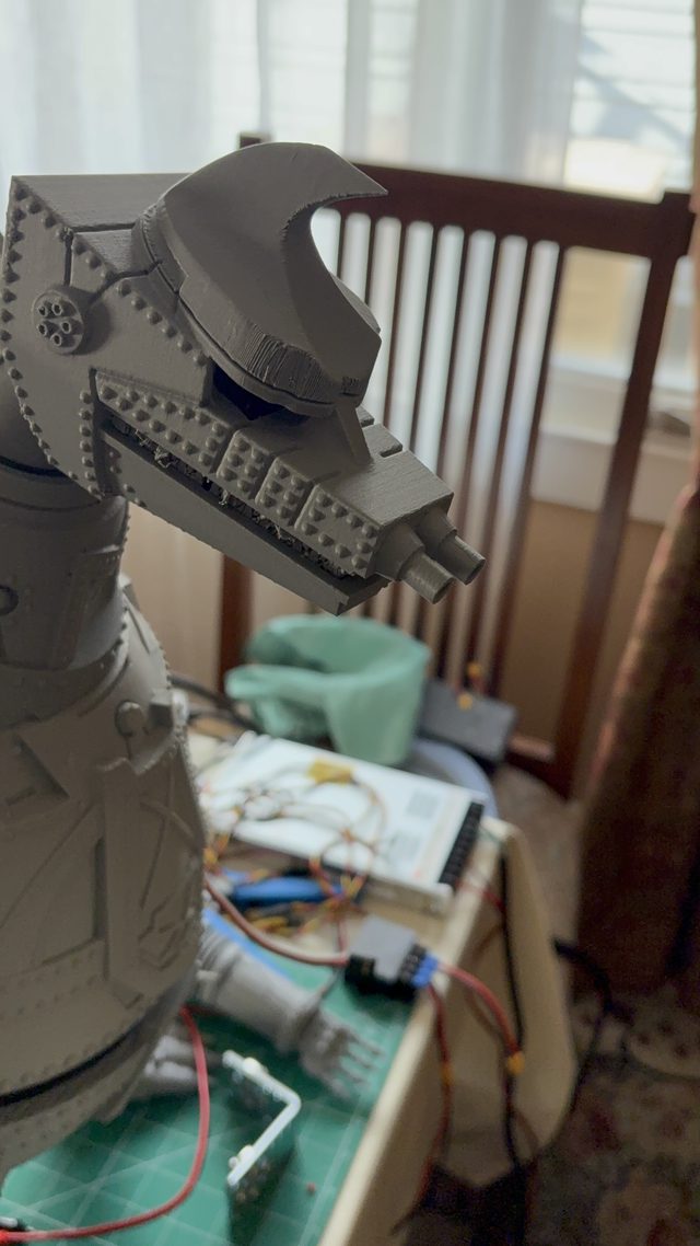 Tall close-up of MechaGodzilla's head in profile showing the toothed jaw and twin snout cannons