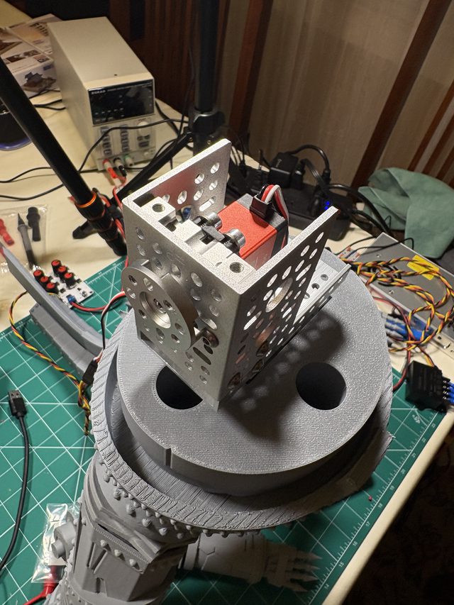 Close-up of the waist servo mounted in its aluminum bracket, bench power supply behind